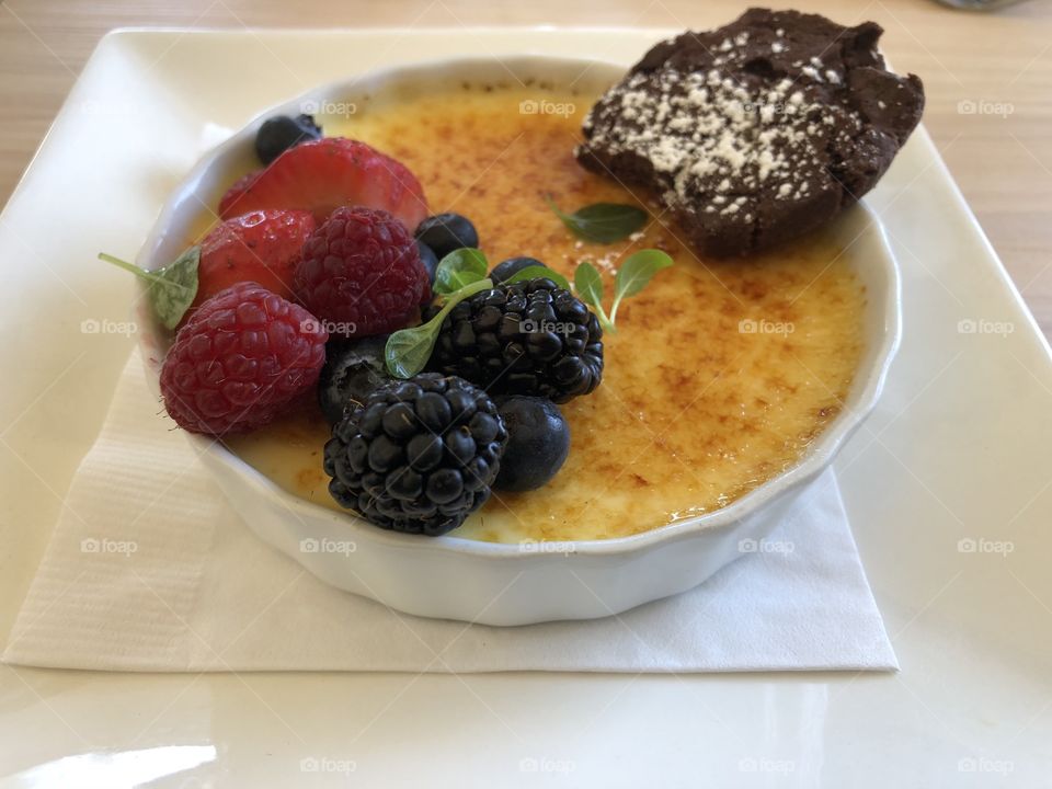 French creme brûlée topped with carmelized sugar and fresh raspberries, blueberries and blackberries 