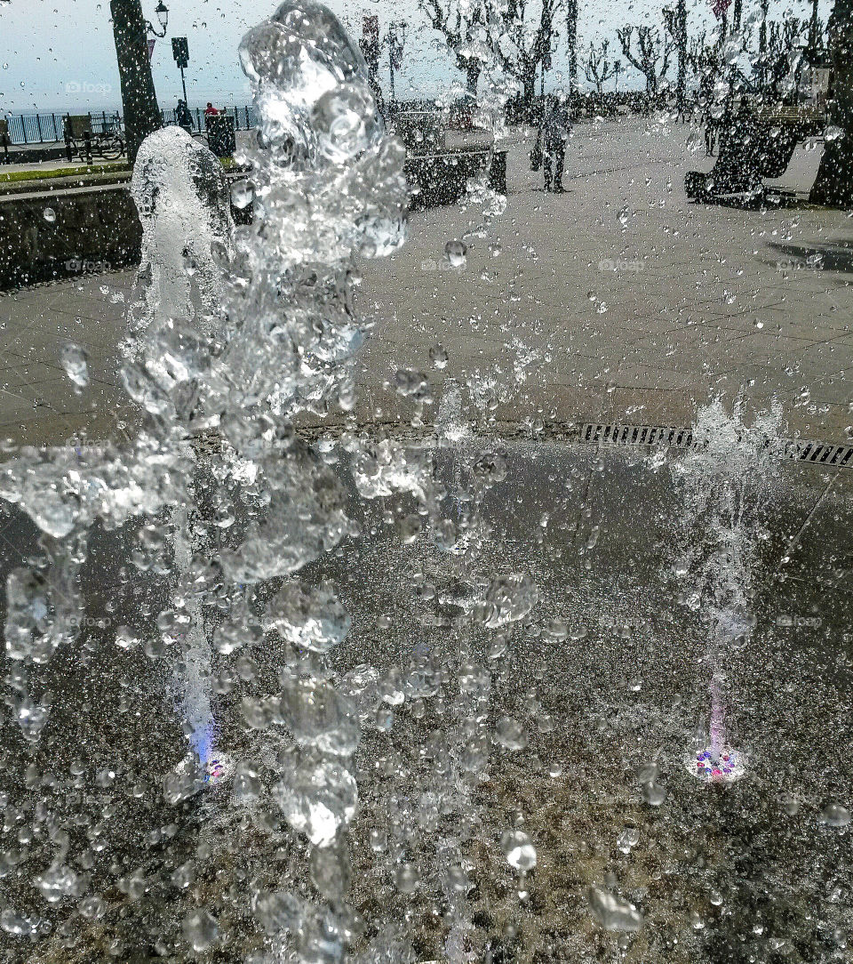 water in motion: Close up of water splash from a fountain with colored light