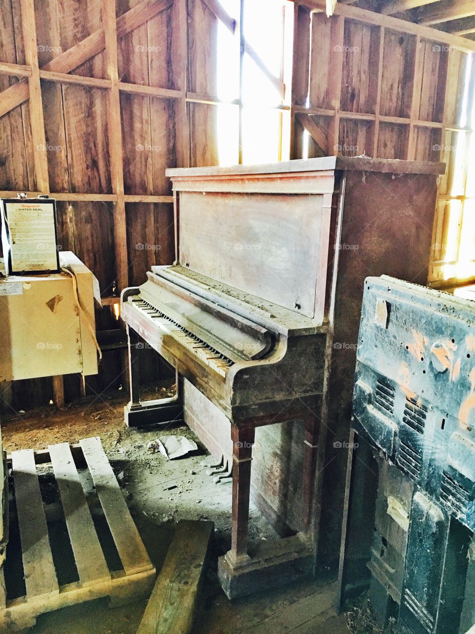 Old barn with holes in it full of old furniture and sunshine. 