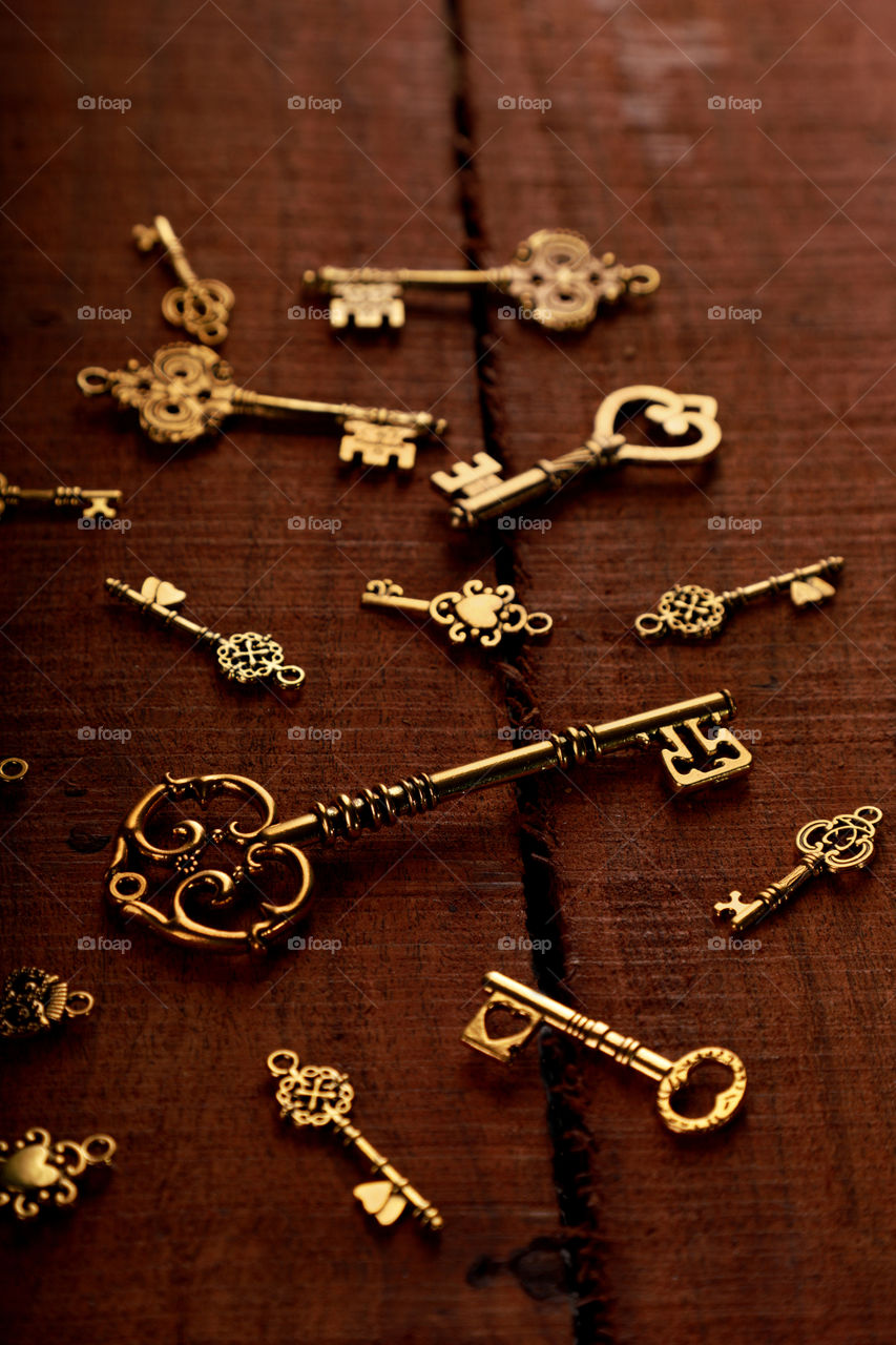 Golden antique keys on wooden background