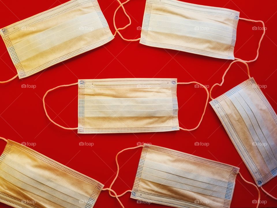 six protective masks resting on a red background