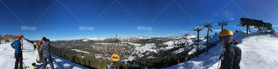 Panorama photo at the top of a ski slope mountain covered in snow