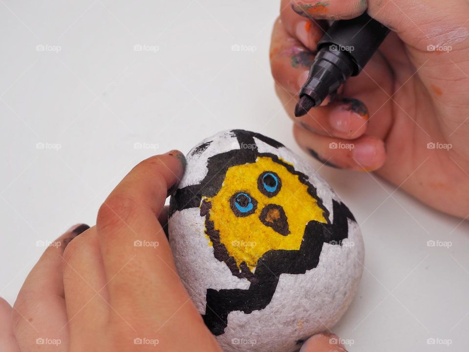 A kid painting a stone