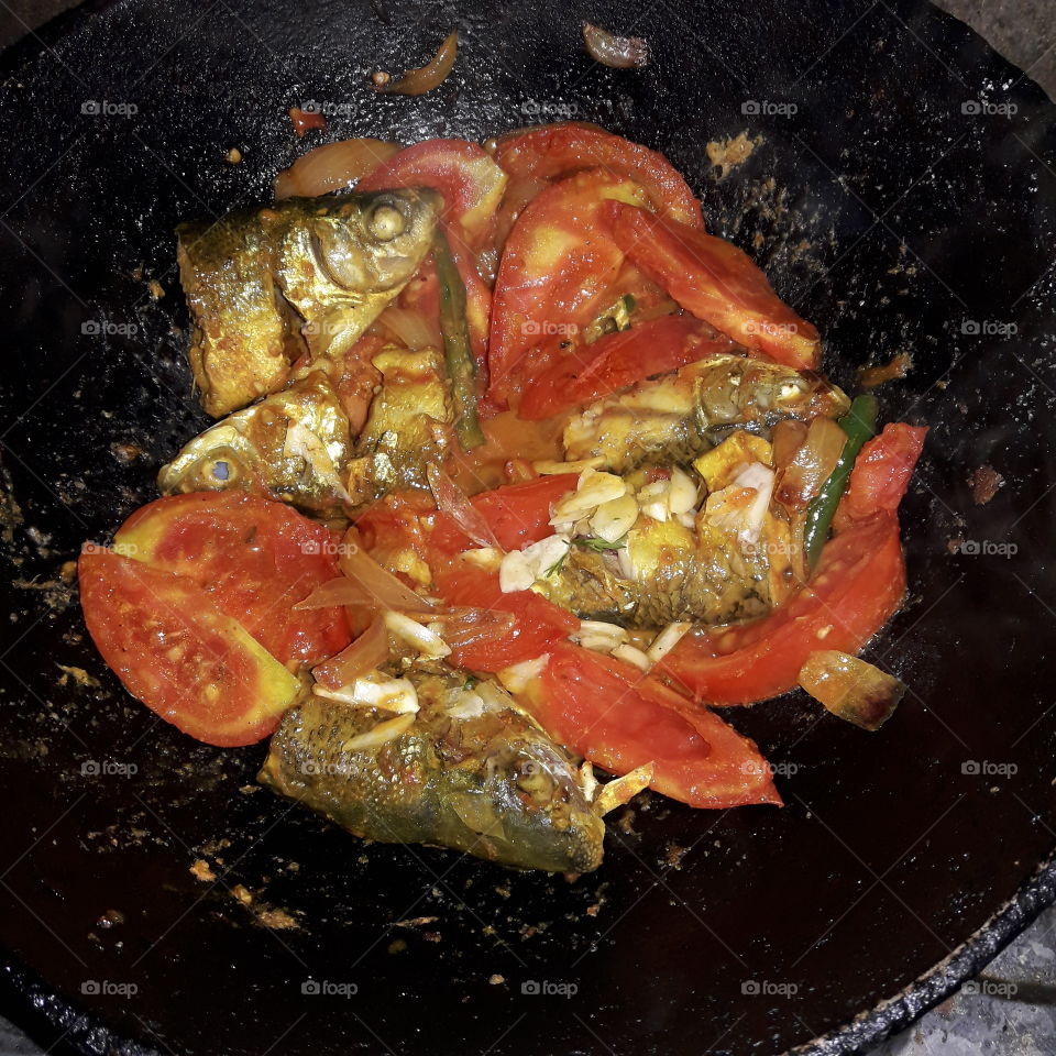 Testy fish fray with tomato and garliks.