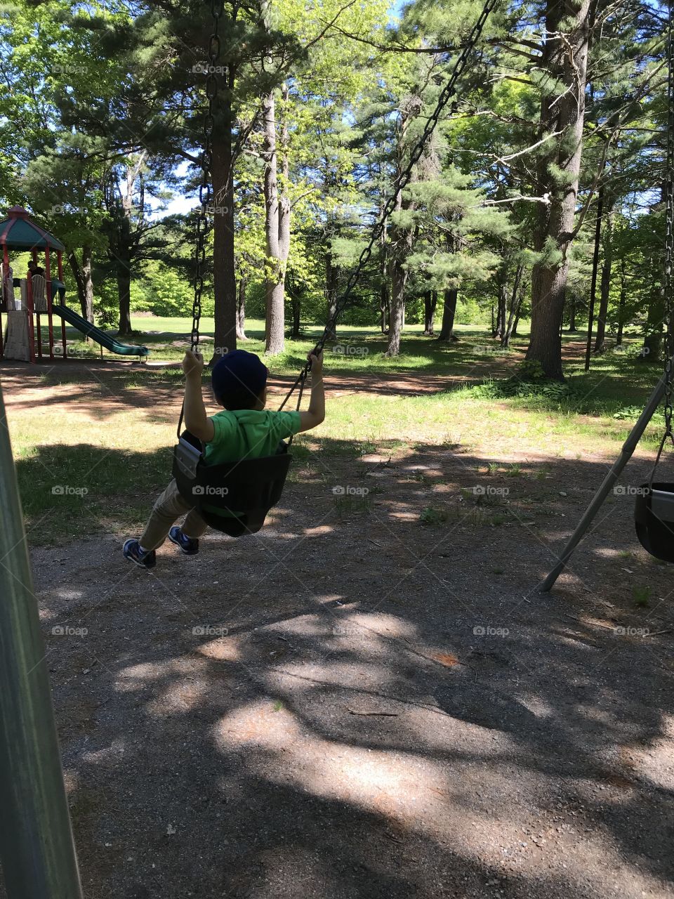 Child on swing in a shaded park