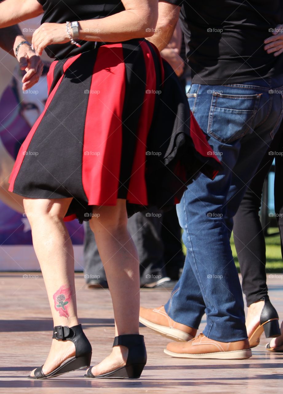 Waist down image, middle age or senior couple jiving to rock and roll and wearing period costumes dress 