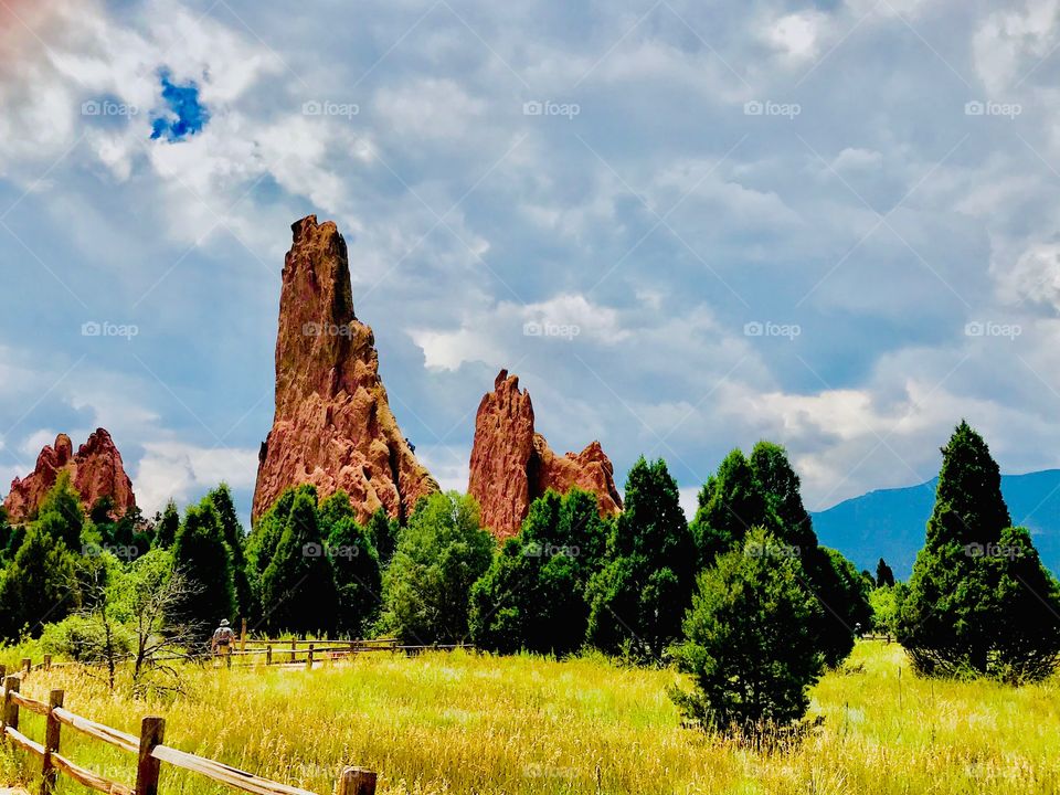 Hiker walking along a trail at garden of the gods in Colorado Springs, Colorado on a beautiful summer day. The place has such breathtakingly beautiful scenery.