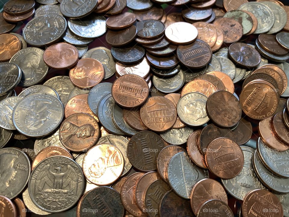 Scattered us coins in the table including pennies, quarters, dimes, nikle, cents.