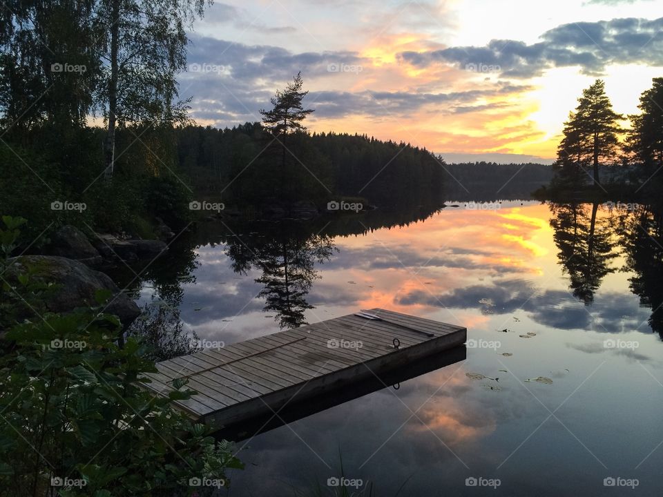 Wooden jetty on lake at sunset