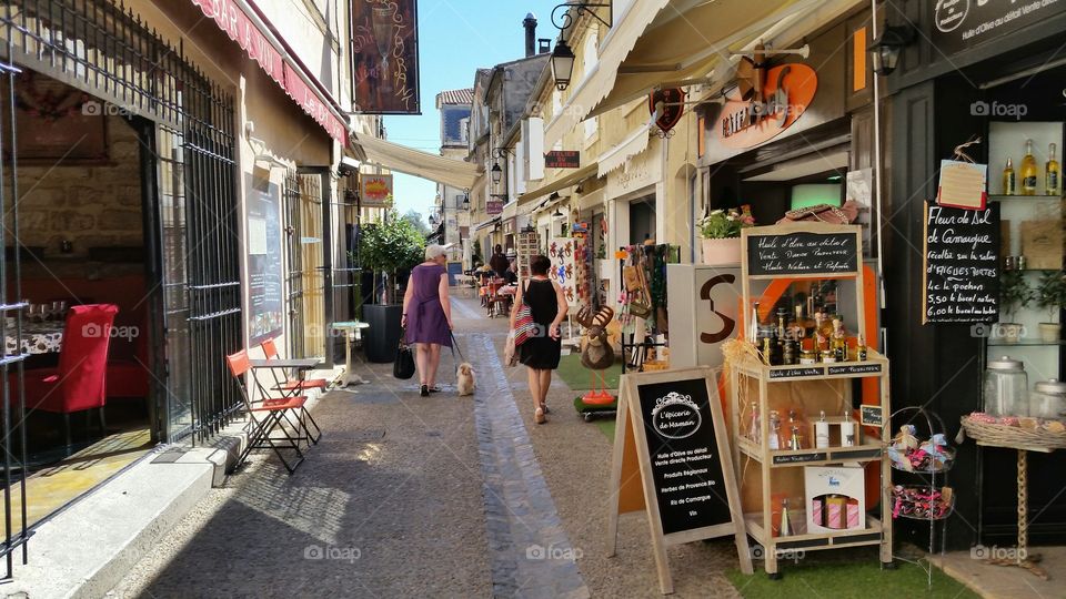 people are walking by the shops in a side street in Camargue, France