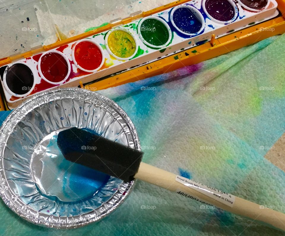 High angle view of watercolor palette and paintbrush