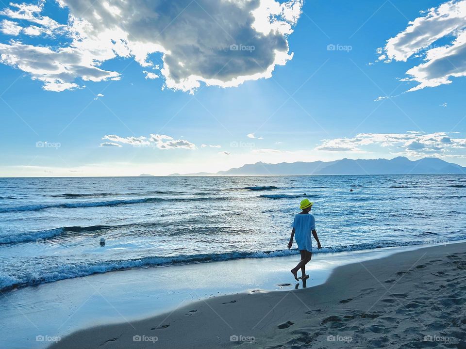 Woman walking alongside of beach 