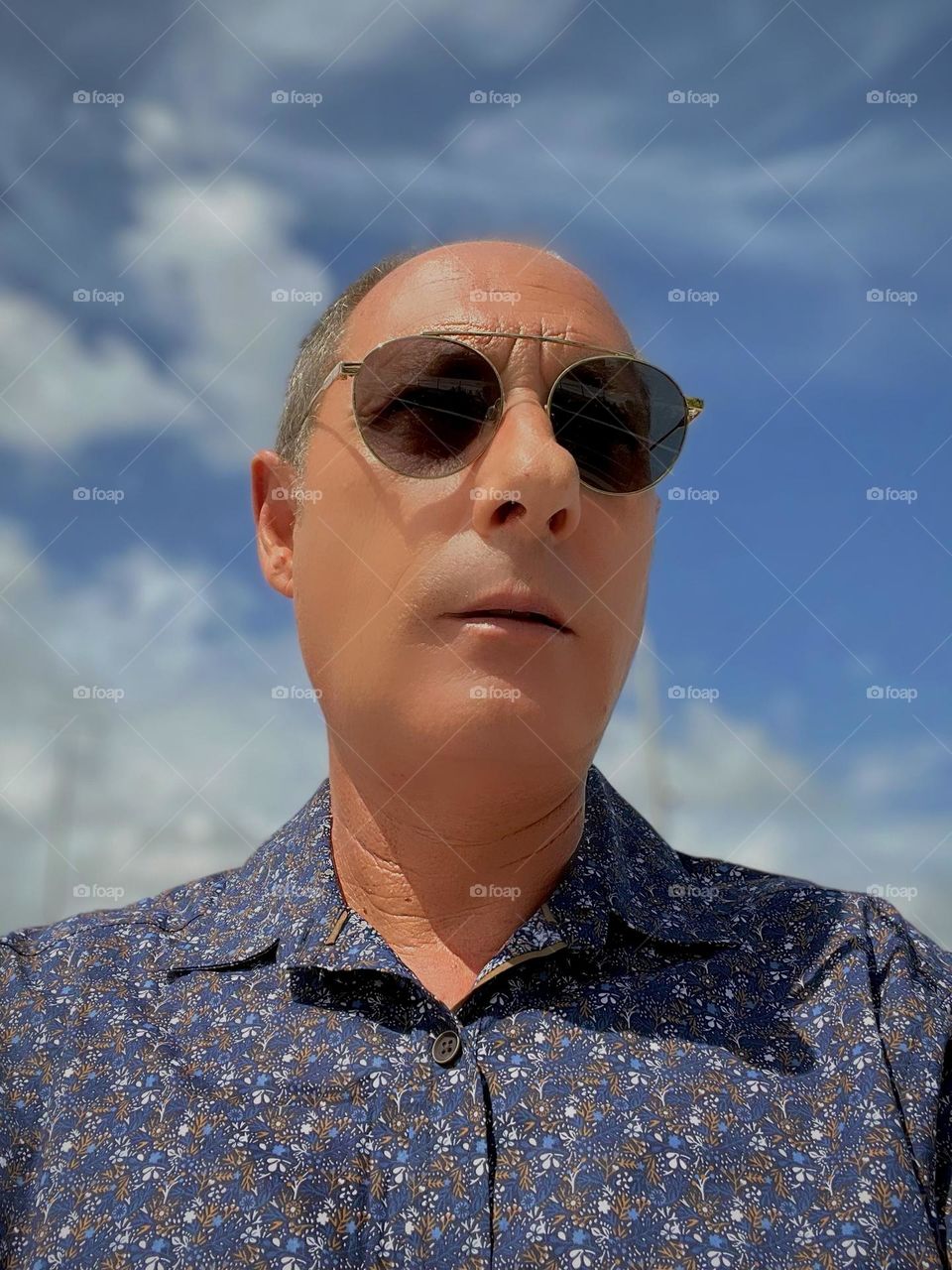 Portrait of a dreamy man with the sky and clouds in the background