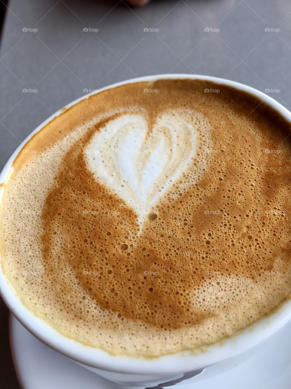 Loving coffee. Heart shape in foam froth of cafe latte in white coffee cup