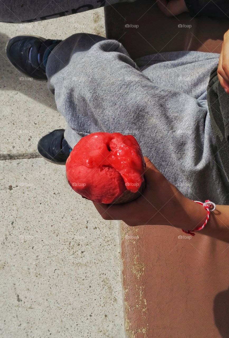 child holding a strawberry ice cream cone