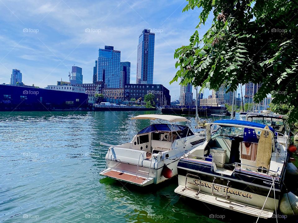 This is “Newtown Creek” by the “Pulaski Bridge” in LIC, Queens with idyllic boats and views all around the NYC boroughs including “Manhattan”. One can see the “Empire State Building” from here. 2023. Hypnotic Productions