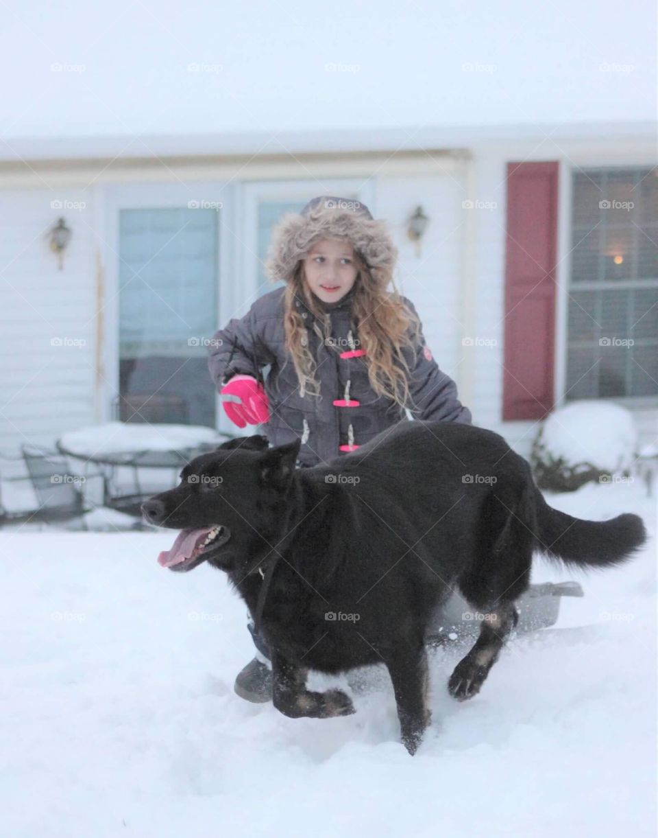 A little girl and her furry companion happily enjoying their time out in the snow. 