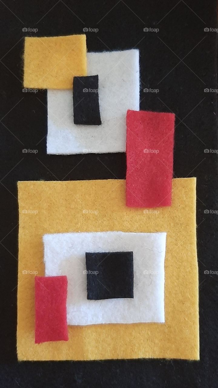Abstract pattern of black white yellow and red felt rectangles
