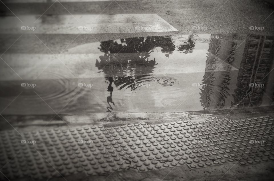 Rain puddle in black and white with reflection