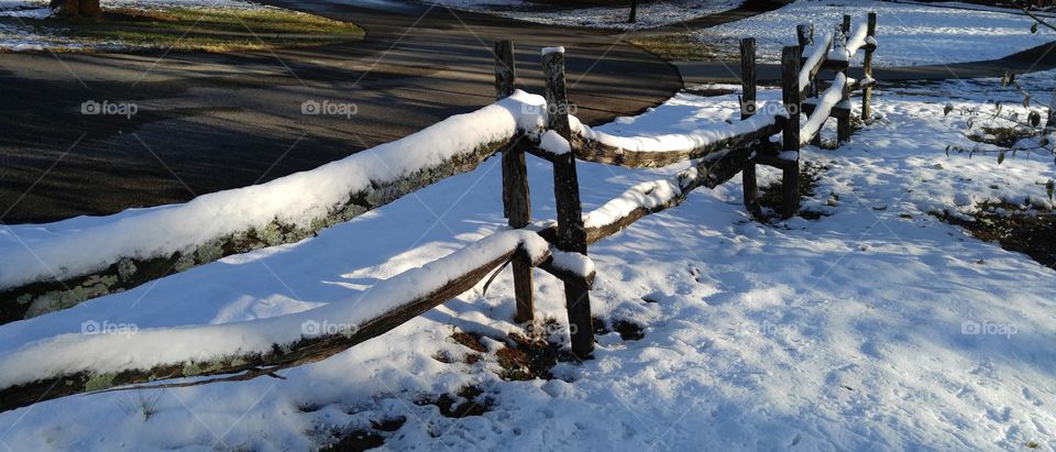 Snow covered wooden fence on campus