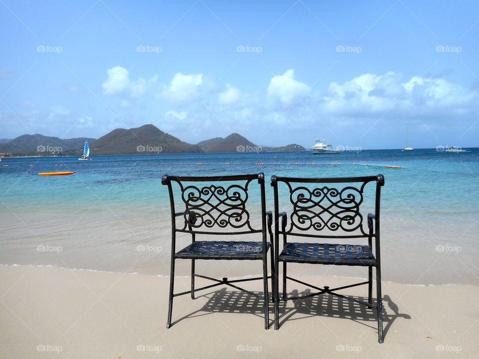 View of empty chair on sand at beach