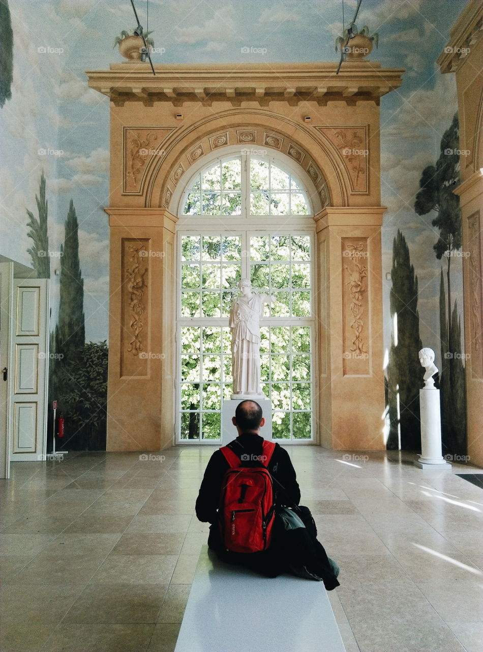 Man looking at a sculpture in  an art gallery.