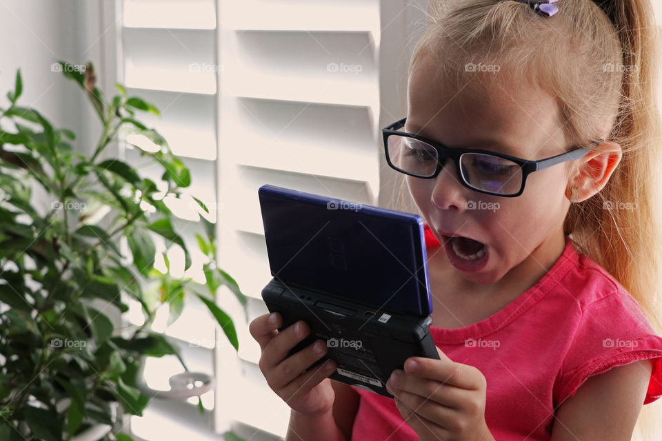 Child playing a video game on a Nintendo DS Lite