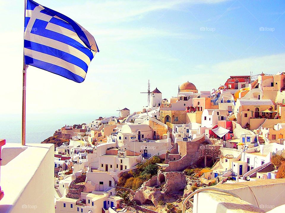 Greek Flag over village of Oia in Santorini, Greece