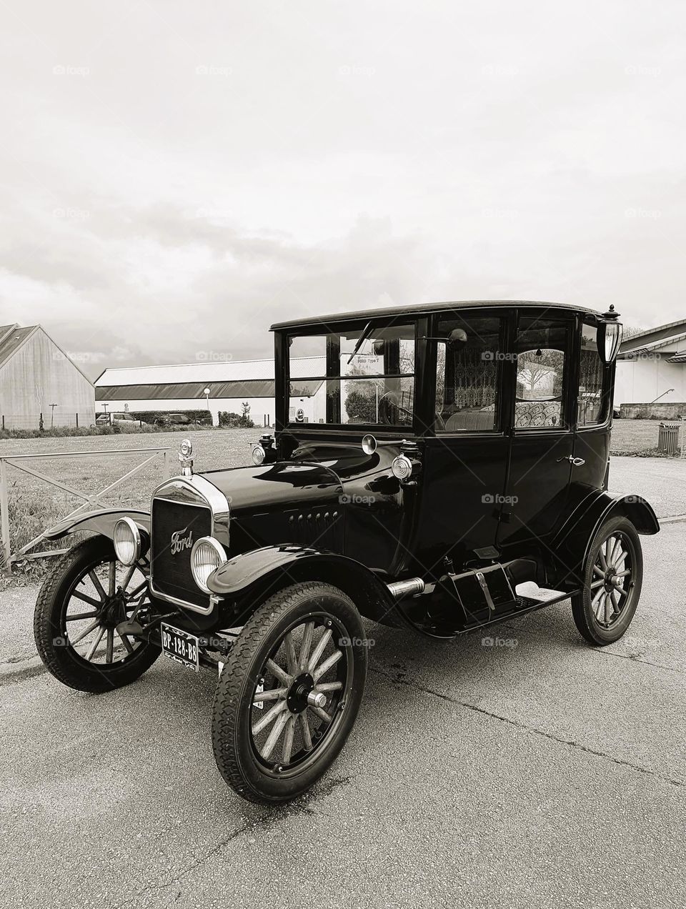 Sepia shot of one side of a Ford T car showing the grill and front lights at Cherbourg car show