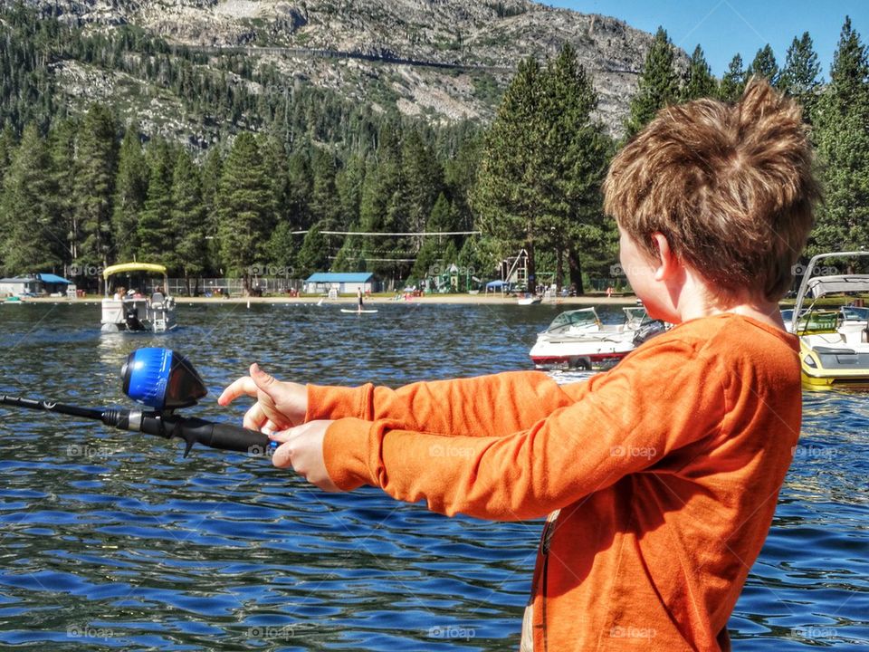 Little Boy Fishing At A Beach. Fishing On A Mountain Lake