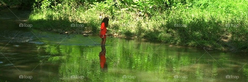child wading in stream