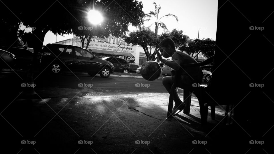 Menino brincando com uma bola.