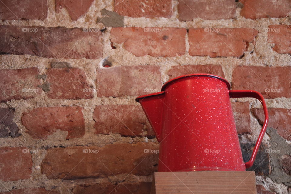 Red carafe against the brick wall 