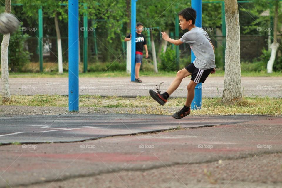 children in the old stadium playing football. moment of impact on the ball