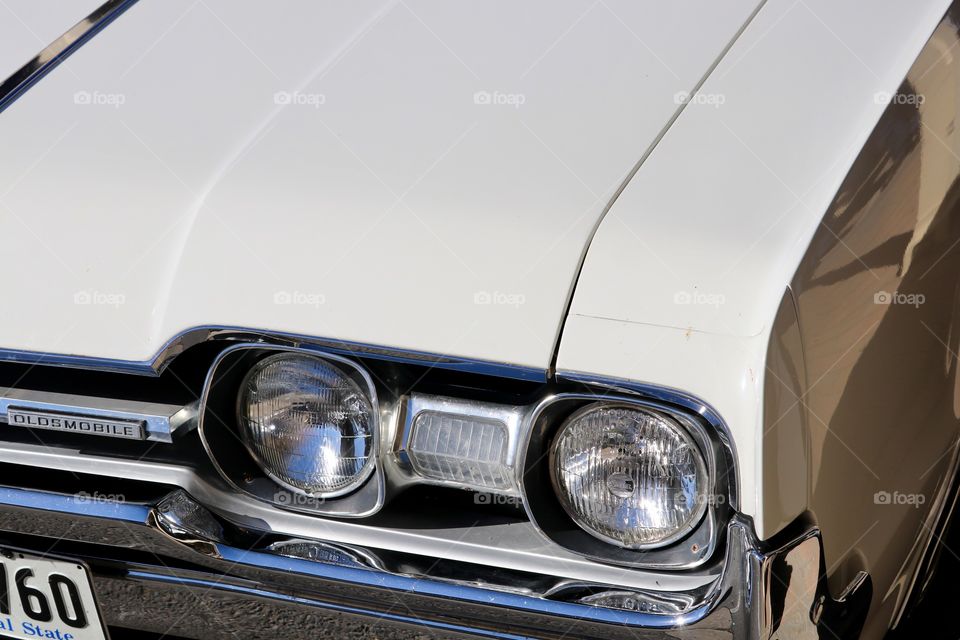 Classic car, Oldsmobile, bonnet hood and headlight view chrome details 