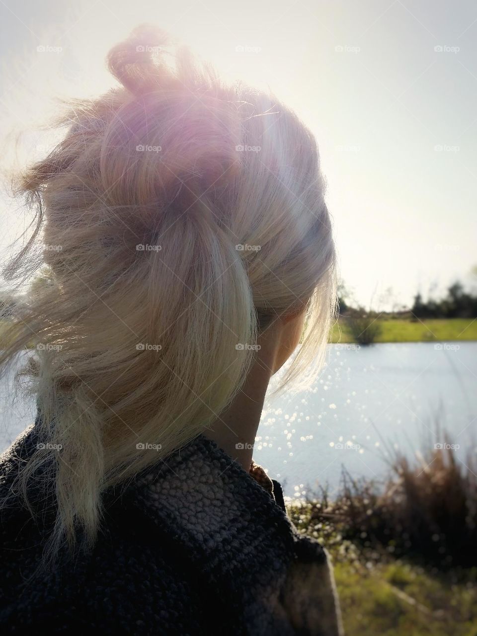 Blond Woman Looking at a Lake at Sunset