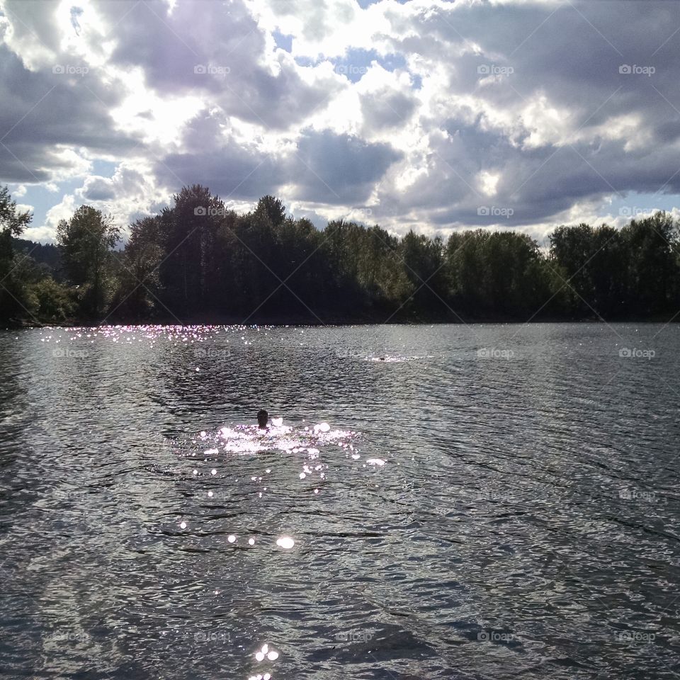 Swimming at dusk. Triathlon training after work in the Willamette river near Portland, Oregon.