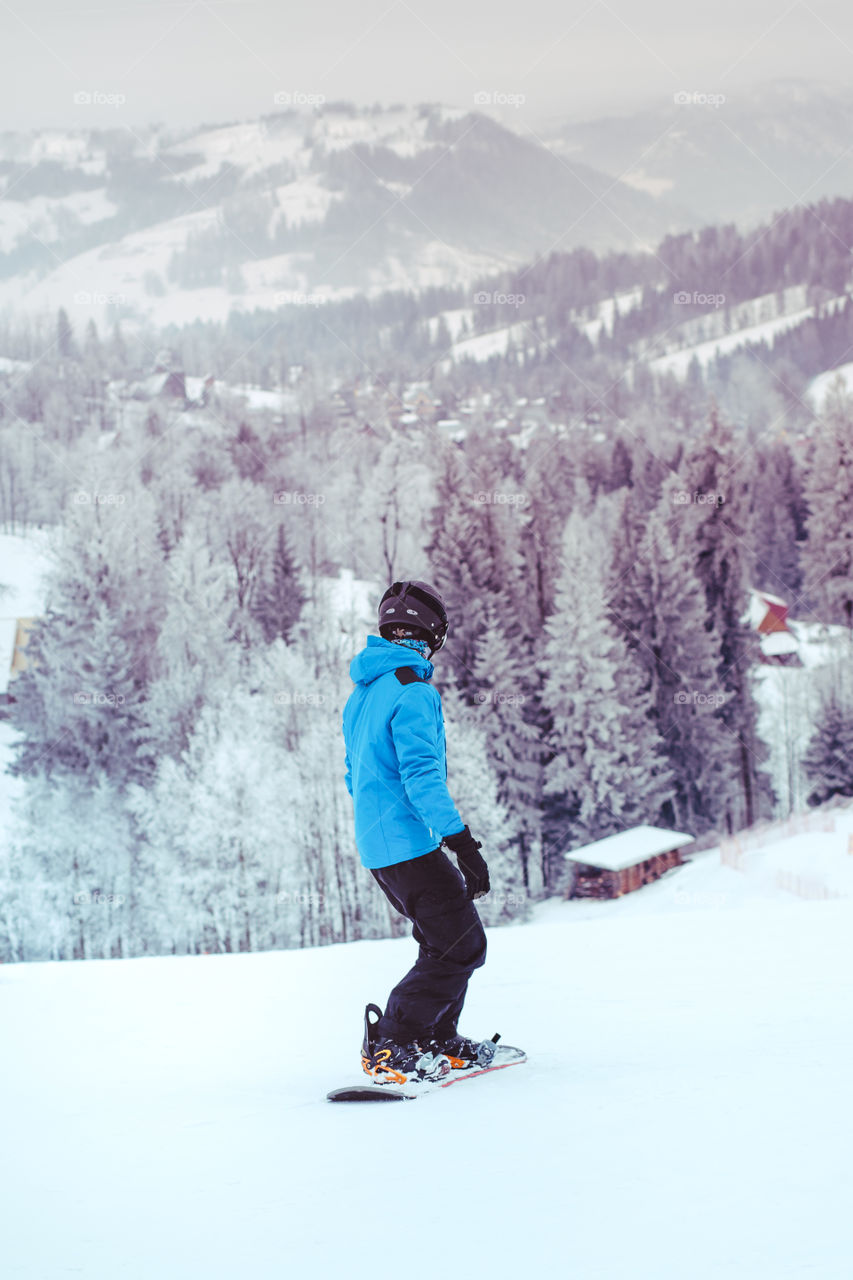 Boy riding a snowboard down the slope
