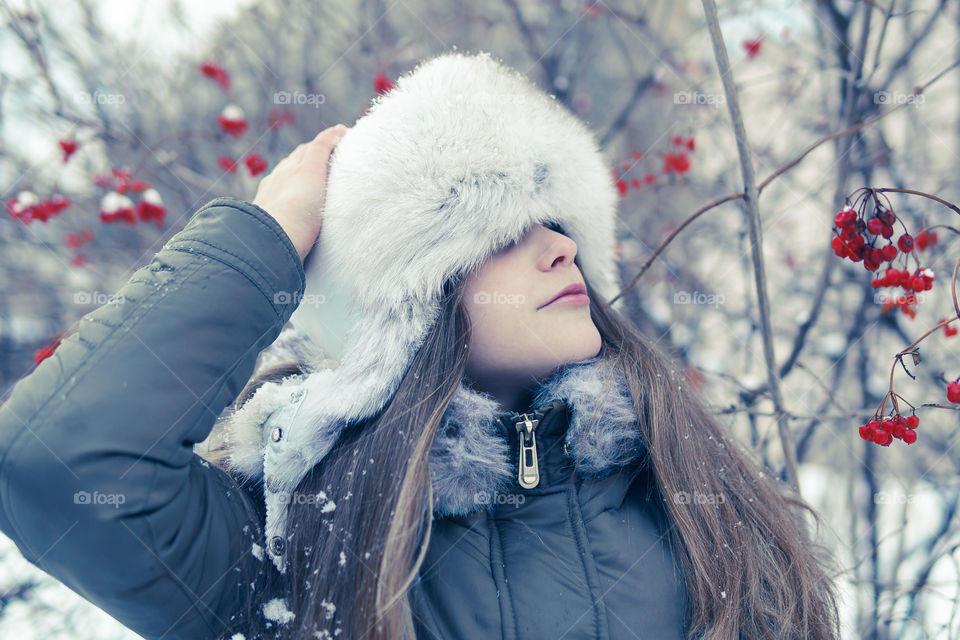 Portrait of a girl with winter hut in frosty day