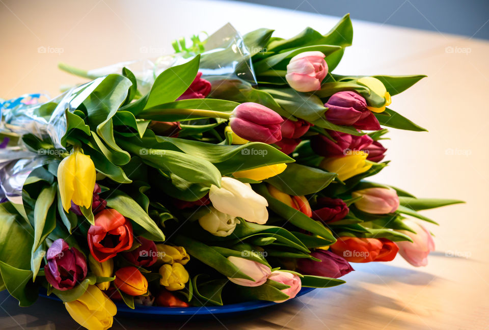 Bouquet of colorful tulips on wood table 