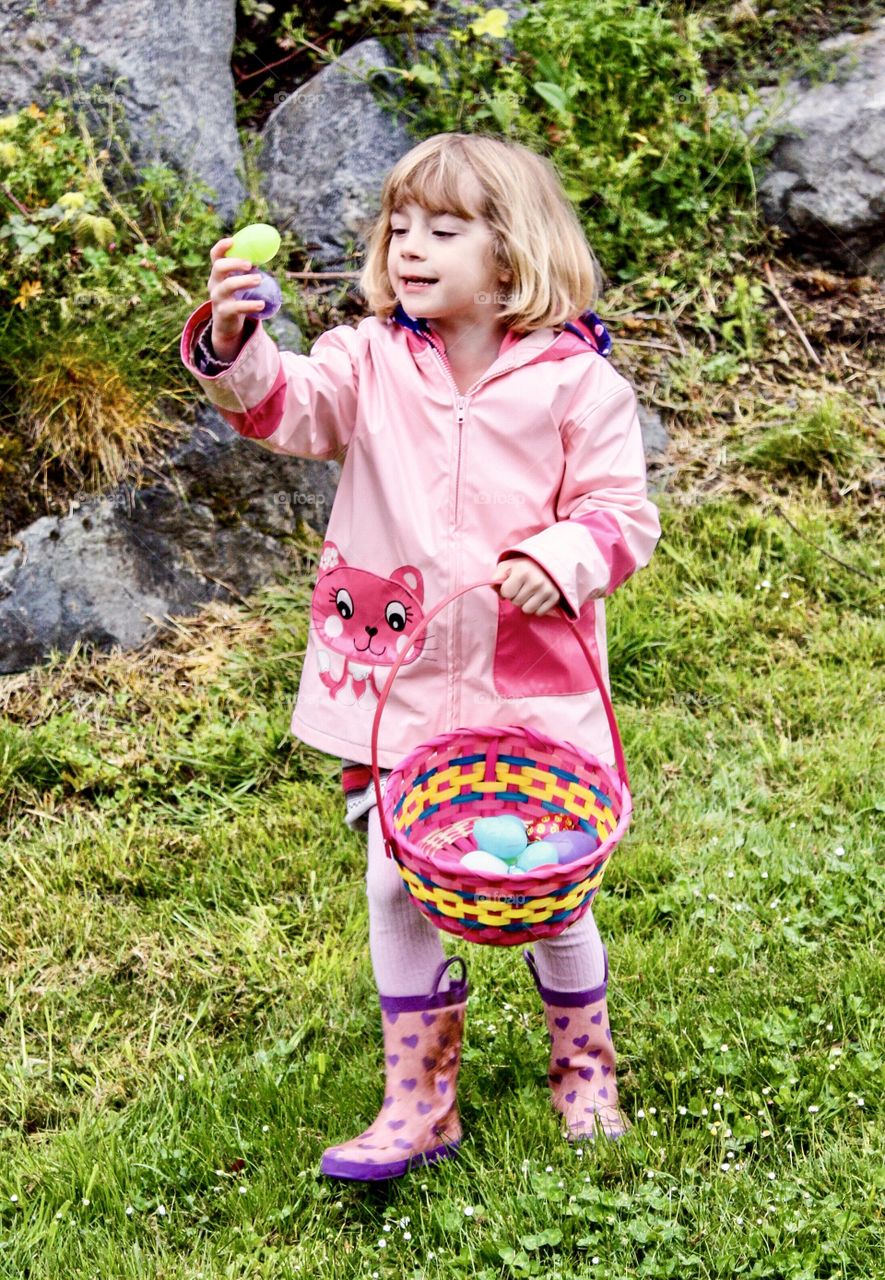 Joyful expression at finding an Easter egg in grassy field 
