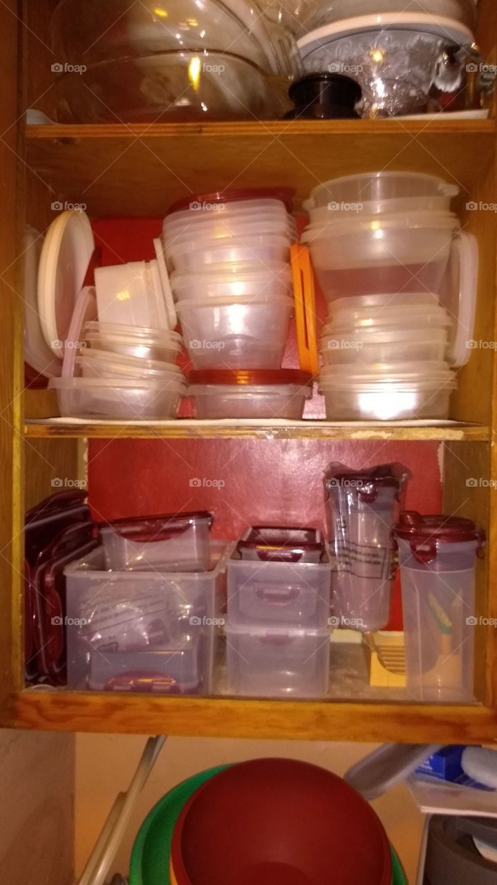 plastic storage containers in the cupboard.