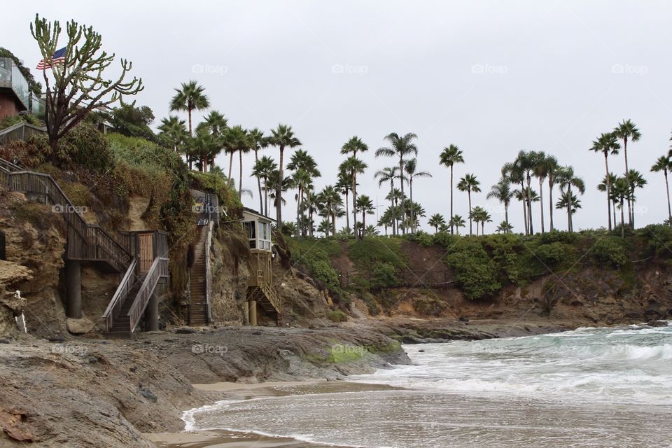 Walkways and staircases up the canyon to homes, waves crashing on the beach