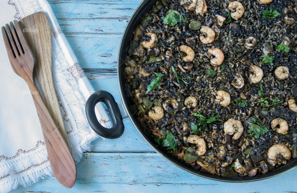 Close-up shot of black rice with cuttlefish and prawns