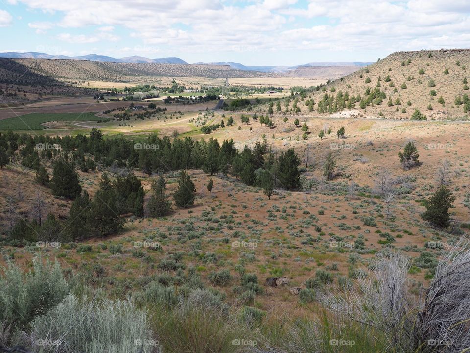 A view down hills into the farming valley and the small rural community of Gateway in Central Oregon on a sunny summer  day. 