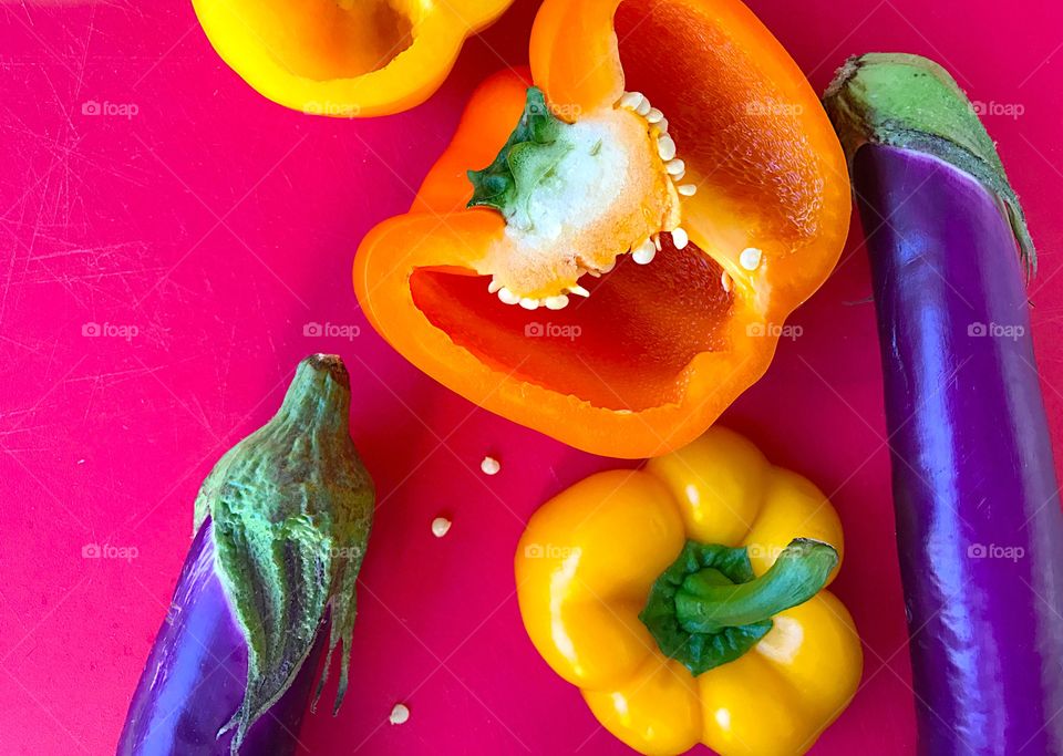 Eggplants and peppers on red