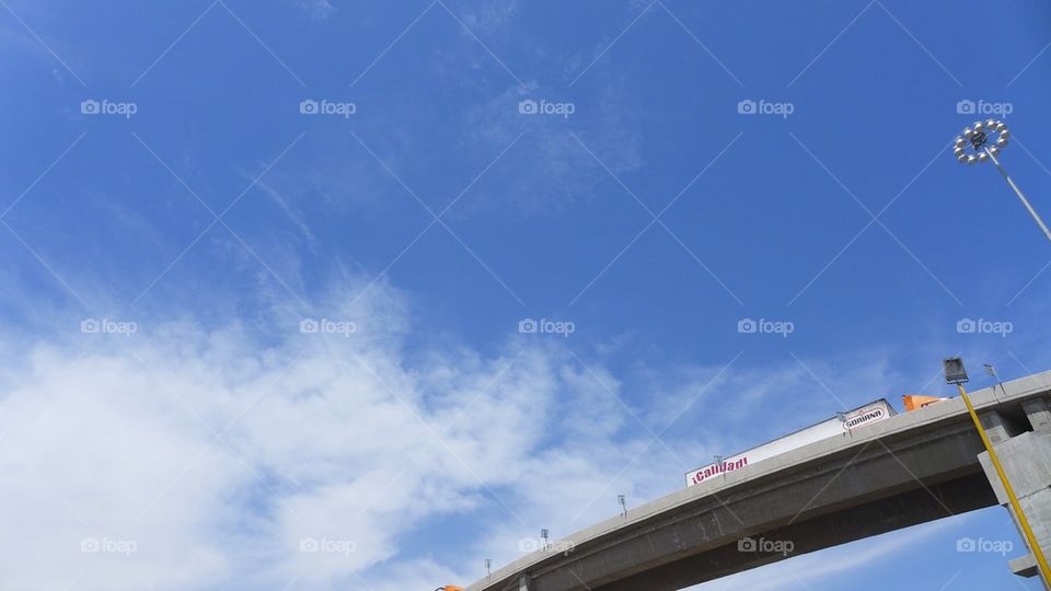 Highway semi trucking on a spectacular sky background