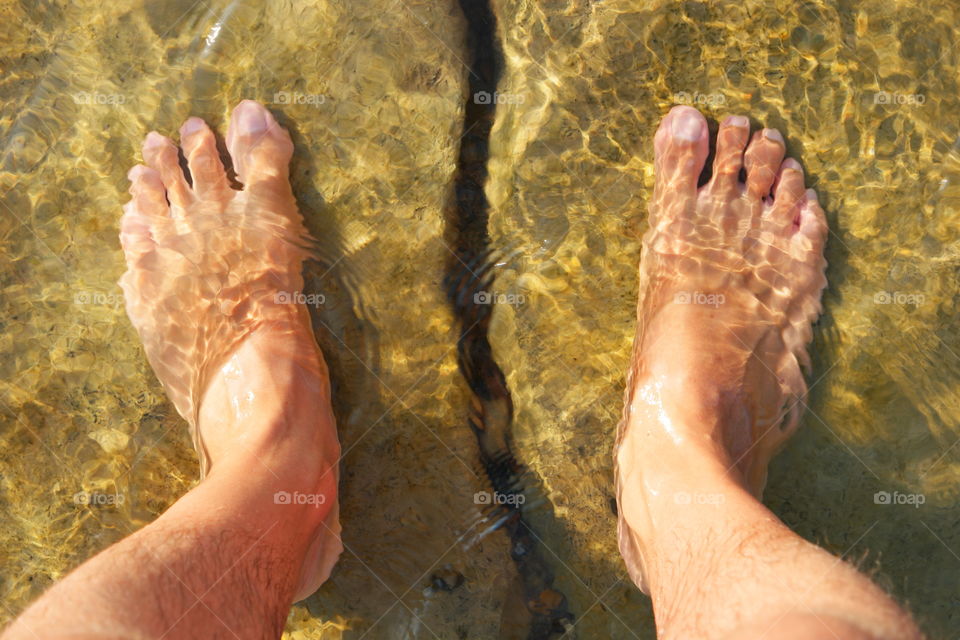 with my feet in the sea of ​​Sicily over a rift between the rocks