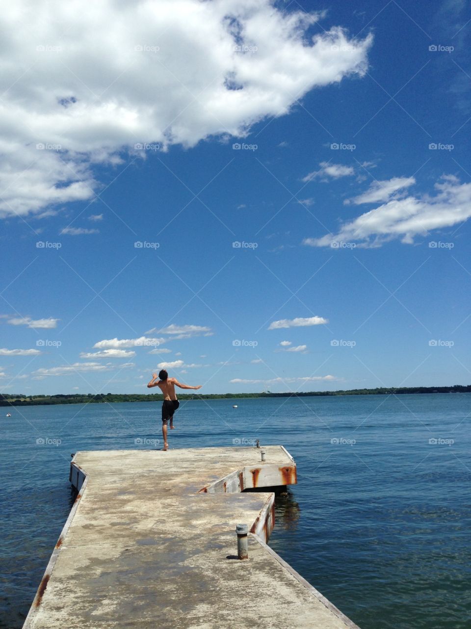 Rear view of man standing on pier over sea