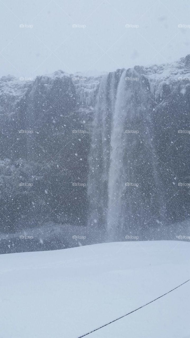 waterfall in iceland with blizzard